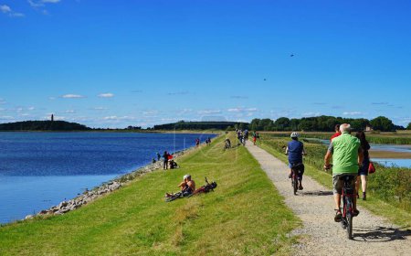 Téléchargez les photos : Image d'une route avec la mer Baltique à gauche et des cyclistes à Fehmarn, en Allemagne - en image libre de droit