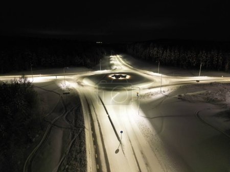 Téléchargez les photos : Vue aérienne d'un rond-point de banlieue vide légèrement éclairé en hiver la nuit - en image libre de droit