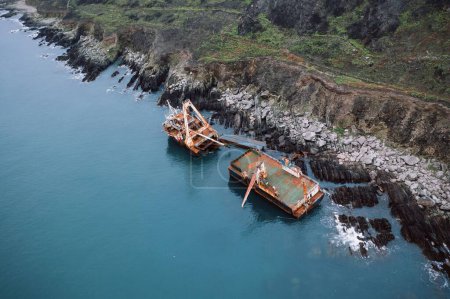 Téléchargez les photos : Vue par drone des navires fantômes rouillés divisés en deux parties près du rivage rocheux à Ballycotton, Irlande - en image libre de droit