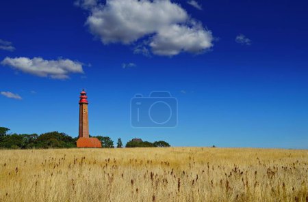 Téléchargez les photos : Une image d'un champ de blé avec un phare en arrière-plan en Allemagne - en image libre de droit