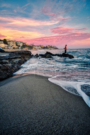 Téléchargez les photos : Plan vertical d'une personne sur la plage au coucher du soleil - en image libre de droit