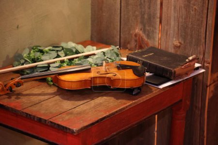 Photo for A cello and the Holy Bible on a wooden table - Royalty Free Image