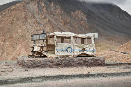 Téléchargez les photos : Une voiture détruite sur la route de l'Himalaya avec une bannière métallique "Please drive safely" dessus - en image libre de droit