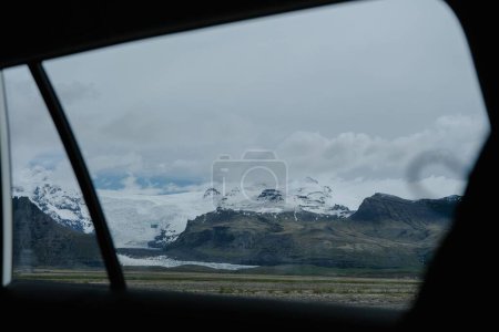 Foto de Una hermosa vista de la montaña cubierta de nieve a través de la ventana del coche - Imagen libre de derechos