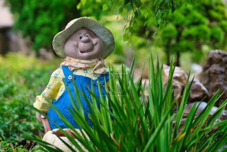 Photo for A close-up shot of a yellow-hatted garden dwarf placed next to plants - Royalty Free Image