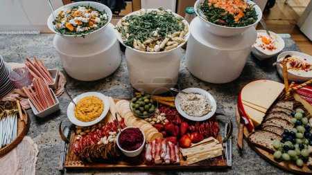 Photo for A high angle shot of a gourmet charcuterie board and salads at an event - Royalty Free Image
