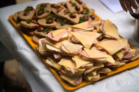 Téléchargez les photos : Une vue de dessus des sandwichs au fromage et des saucisses sur un plateau jaune - en image libre de droit