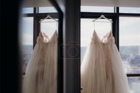 Téléchargez les photos : Une sélection de la robe d'une mariée suspendue dans une pièce - en image libre de droit
