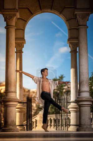 Photo for A young man dancing classical ballet in the streets of Barcelona with a beautiful background - Royalty Free Image