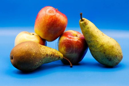 Photo for A bunch of of ripe and sweet apples and pears isolated on a empty blue background - Royalty Free Image
