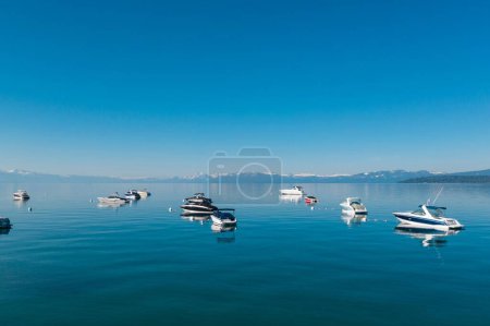 Téléchargez les photos : Les bateaux dans l'eau transparente du lac Tahoe sous un ciel bleu clair aux États-Unis. - en image libre de droit