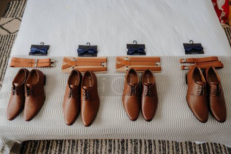 Photo for A close-up shot of the groom's mates shoes on a bed - Royalty Free Image