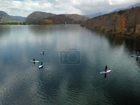 Photo for A beautiful shot of a people paddling in a lake surrounded by autumn colored hills - Royalty Free Image