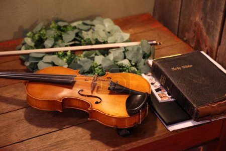 Photo for A cello and the Holy Bible on a wooden table - Royalty Free Image
