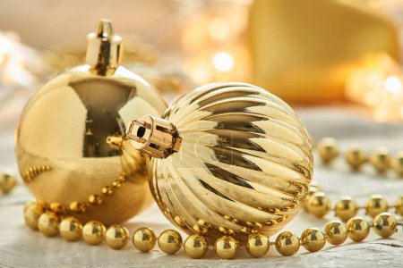 Téléchargez les photos : Un gros plan d'ornements de Noël dorés placés sur une surface blanche - en image libre de droit