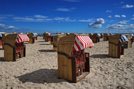 Photo for The bench-cabins on the sandy beach in Travemuende alongside the Baltic Sea on a sunny day - Royalty Free Image