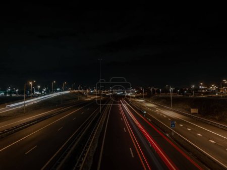 Foto de Una toma aérea de larga exposición de los senderos de luz del coche en la carretera de la ciudad por la noche - Imagen libre de derechos