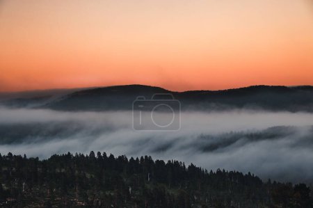 Téléchargez les photos : Un paysage naturel avec une montagne cachée dans le brouillard au coucher du soleil dans le nord de la Norvège - en image libre de droit