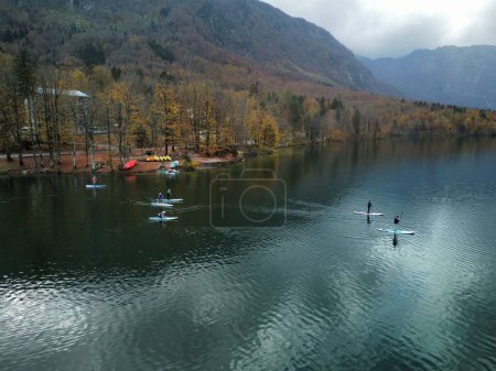 Photo for A beautiful shot of a people paddling in a lake surrounded by autumn-colored hills - Royalty Free Image