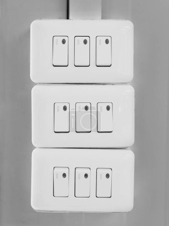 Photo for A vertical shot of white gang way light switches on a wall - Royalty Free Image