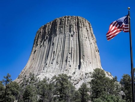 Téléchargez les photos : Le célèbre Monument National de la Tour des Diables et un drapeau américain dans le Wyoming, USA - en image libre de droit