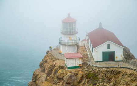 Téléchargez les photos : Le phare de Point Reyes recouvert de brouillard entouré par la mer dans le comté de Marin, Californie - en image libre de droit