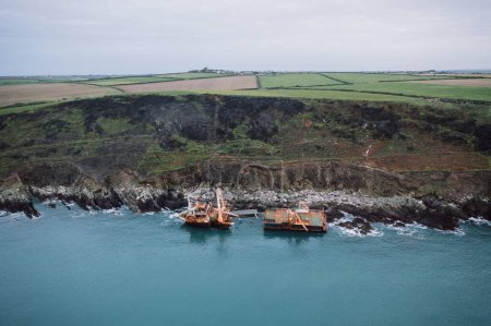 Téléchargez les photos : Vue par drone des navires fantômes rouillés divisés en deux parties près du rivage rocheux à Ballycotton, Irlande - en image libre de droit