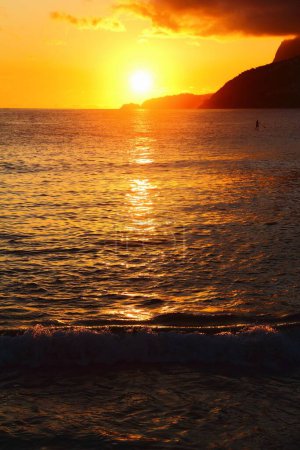 Foto de Una toma vertical de una majestuosa puesta de sol en la playa de Ipanema en Río de Janeiro, Brasil - Imagen libre de derechos