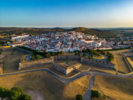 A drone shot of the Elvas castle in Portugal with residential buildings on its background