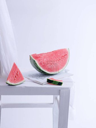 Photo for A vertical shot of slices of watermelon on a white wooden board on a white background - Royalty Free Image
