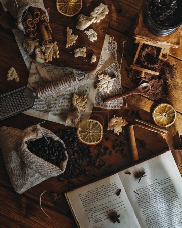 Foto de Una vista vertical de una mesa de madera con un libro abierto frutas secas y café - Imagen libre de derechos