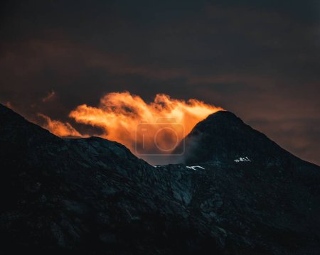 Foto de Las nubes anaranjadas sobre las montañas rocosas durante la puesta del sol - Imagen libre de derechos