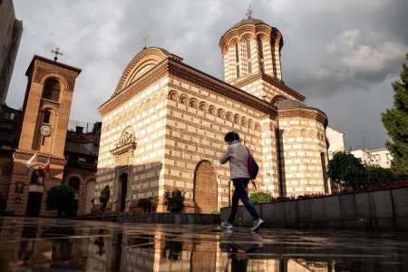 Foto de Una persona caminando por una iglesia ortodoxa iluminada por el sol en Bucarest, Rumania - Imagen libre de derechos