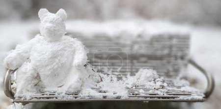 Téléchargez les photos : Un gros plan d'un drôle d'ours de neige assis sur un banc - en image libre de droit