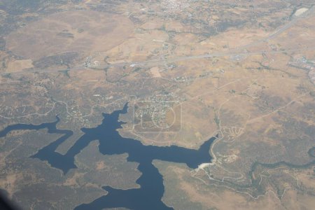 Téléchargez les photos : Vue aérienne depuis le ciel d'un lac qui coule à Madrid en plein jour - en image libre de droit