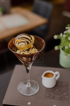 Photo for A closeup of delicious caramel ice cream balls melting into a glass in a bar - Royalty Free Image