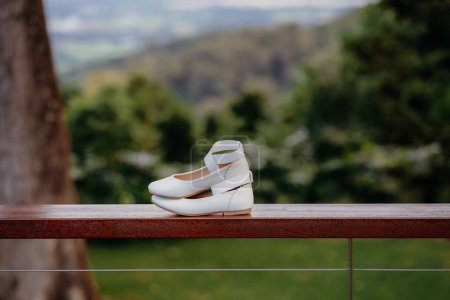 Foto de Un primer plano de un par de zapatos de niño colocados en una valla - Imagen libre de derechos