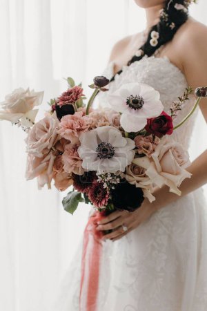 Photo for A bride in a white elegant wedding dress holding a big bouquet - Royalty Free Image