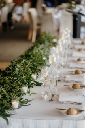 Foto de Una toma vertical de plantas verdes en una mesa de cena arreglada - Imagen libre de derechos