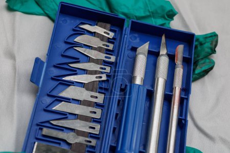 Téléchargez les photos : Une boîte avec des instruments chirurgicaux sur des gants en plastique sales et sanglants - en image libre de droit