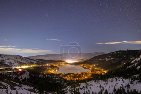 Photo for A landscape of Lake Tahoe surrounded by illuminated roads under a starry sky in the US - Royalty Free Image