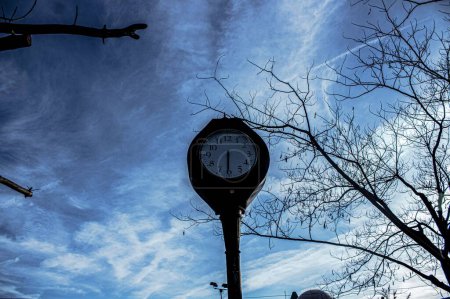 Foto de Una toma de bajo ángulo de un reloj de calle bajo el cielo azul que muestra las seis y media - Imagen libre de derechos