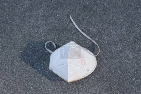 Foto de Una máscara protectora usada en un suelo de asfalto - Imagen libre de derechos