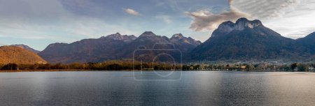 Téléchargez les photos : Une vue panoramique panoramique panoramique sur un lac tranquille entouré de montagnes à feuilles persistantes par une belle journée - en image libre de droit