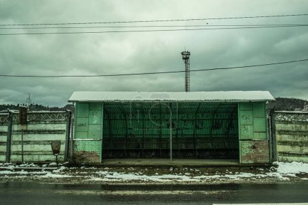 Téléchargez les photos : Un bâtiment abandonné en hiver avec un ciel sombre et nuageux - en image libre de droit