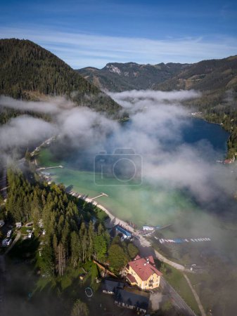 Téléchargez les photos : Vue verticale d'un étang entre des montagnes forestières dans une zone rurale par une journée brumeuse à Mariazell, Autriche - en image libre de droit
