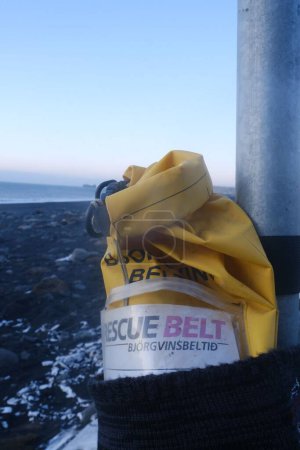 Foto de Un primer plano vertical de una bolsa impermeable amarilla unida a un poste de metal en un barco - Imagen libre de derechos