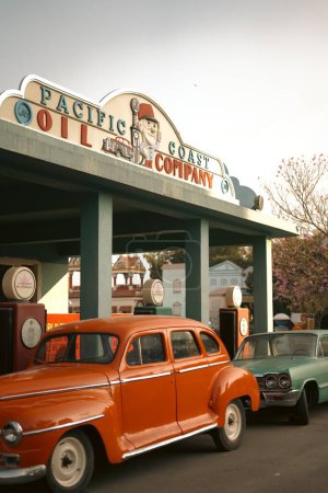 Photo for A vertical shot of vintage cars parked against a petrol station in India - Royalty Free Image