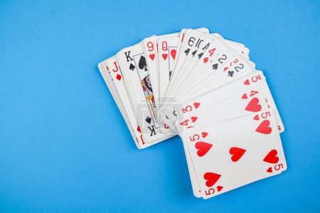 Téléchargez les photos : Une vue de dessus d'un paquet de cartes à jouer isolé sur un fond bleu - en image libre de droit