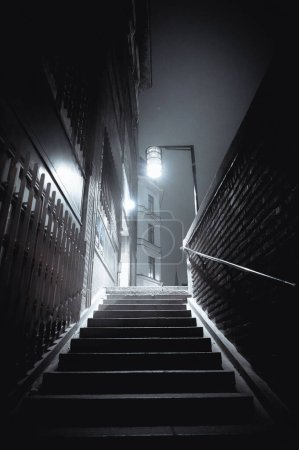 Foto de Un plano vertical en blanco y negro de escaleras que conducen a la calle por la noche en Estocolmo - Imagen libre de derechos